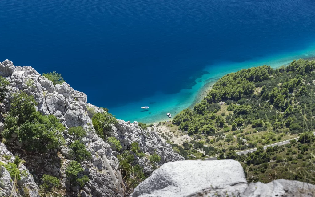 Calm Sea Rocky Coastline Lush Greenery Blue Sky Clear Waters