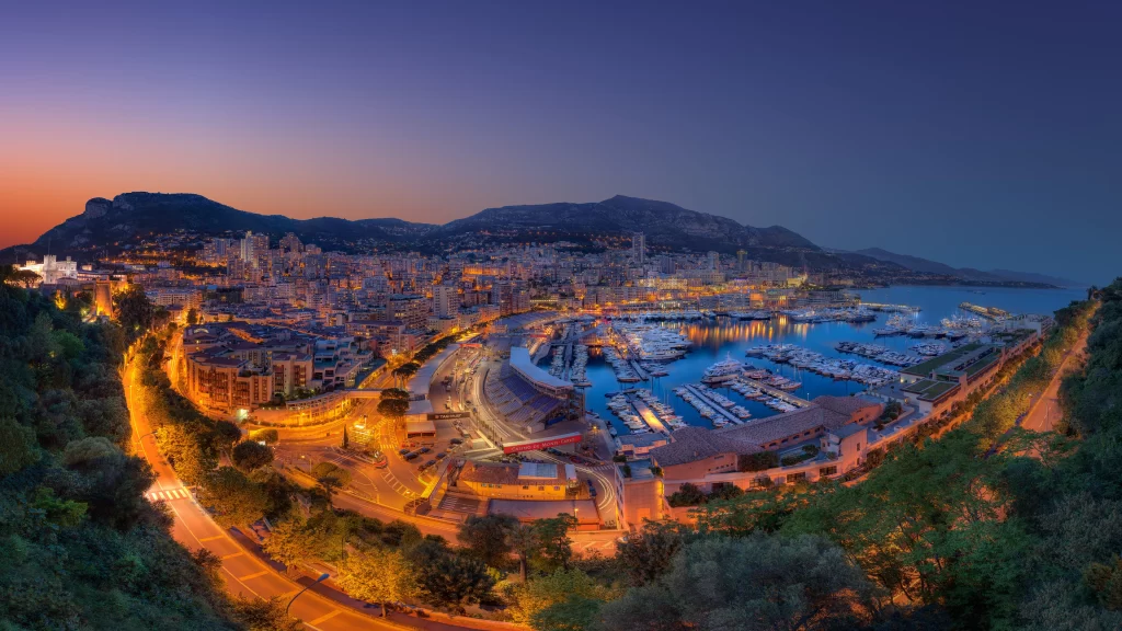 Cityscape sunset harbor boats buildings mountains twilight lights
