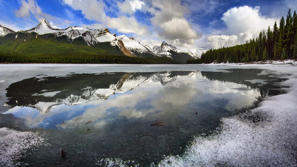 Frozen lake, snow-capped mountains, clear sky, reflection, forest, tranquil