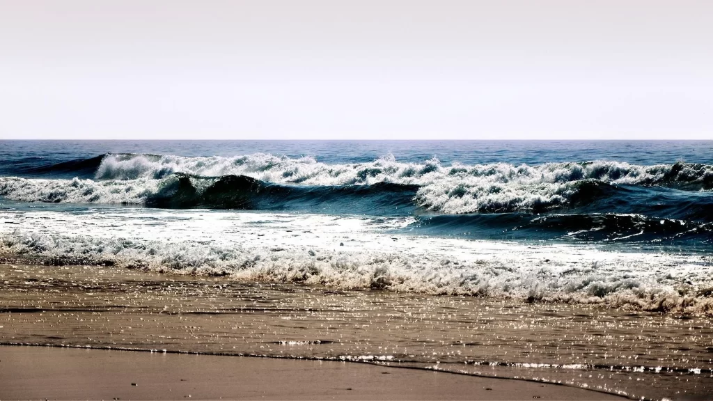 Ocean waves beach sand sky horizon sunlight