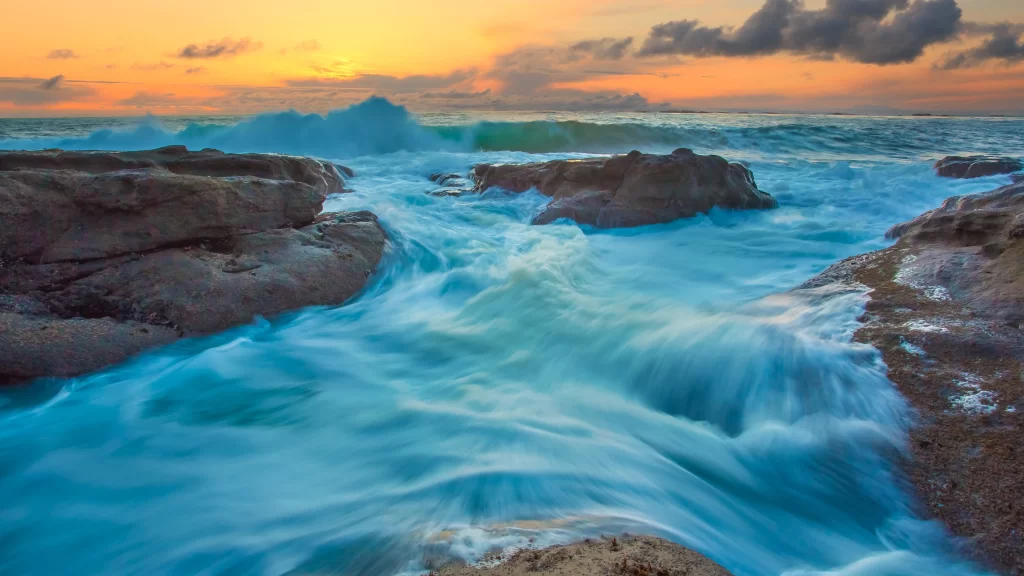 Ocean waves sunset rocks sky clouds