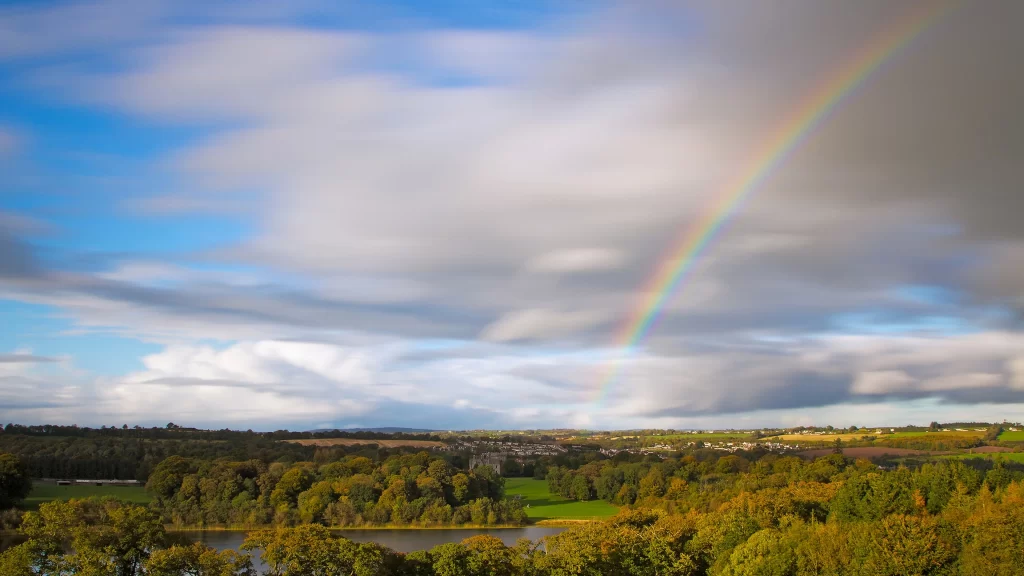 Rainbow clouds landscape trees sky sunlight