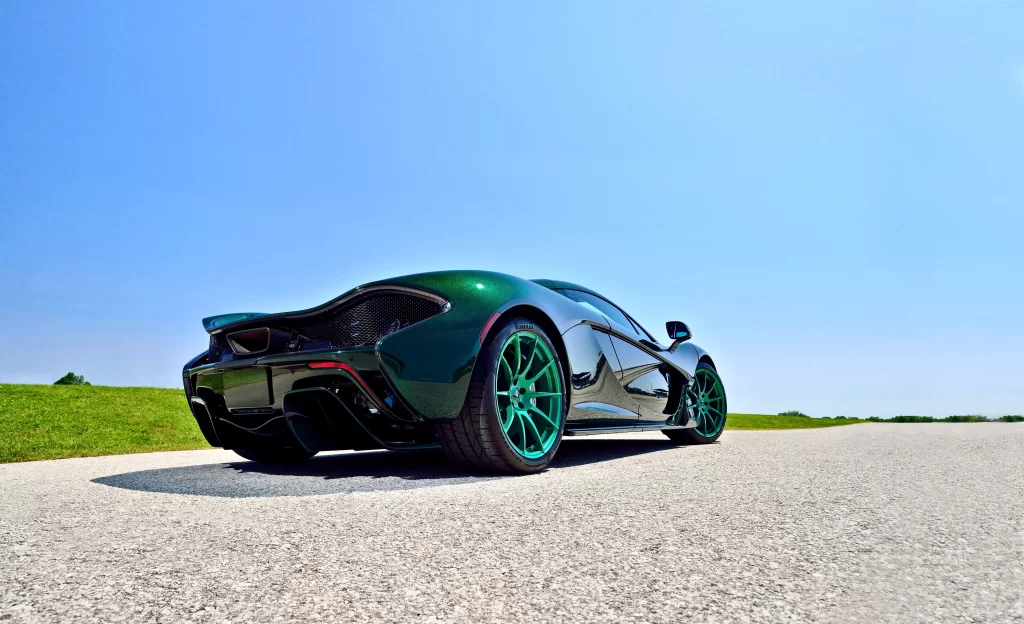 Sports car green wheels road sky grass