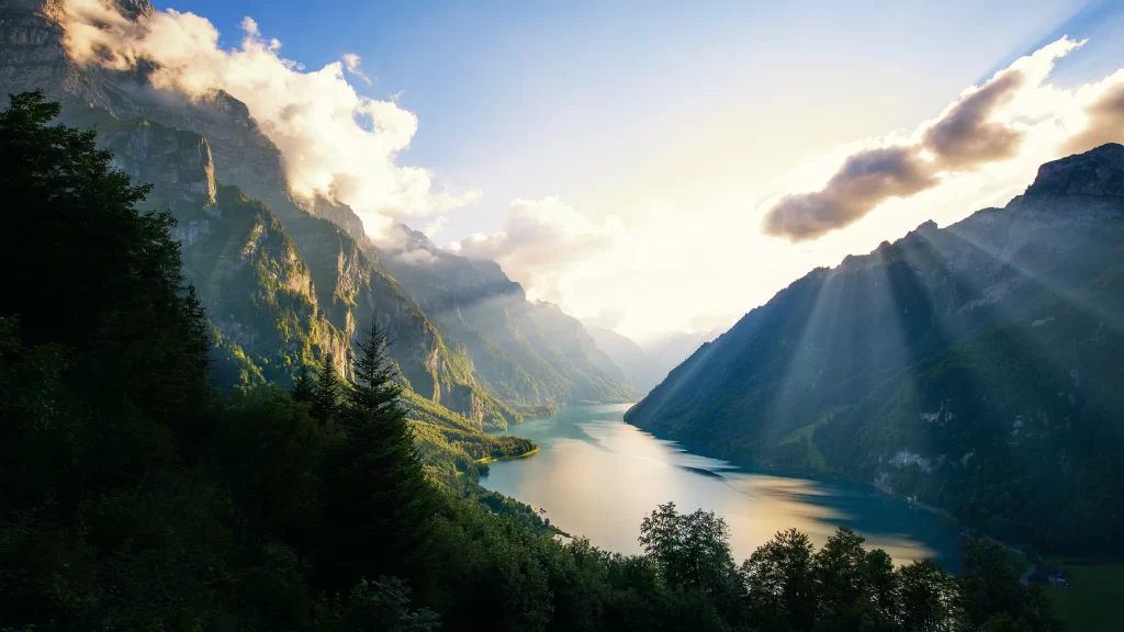 Sunlight mountains lake clouds greenery reflection landscape tranquility