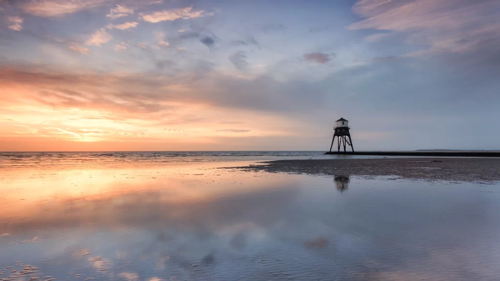 Sunset beach lighthouse reflection clouds tranquil