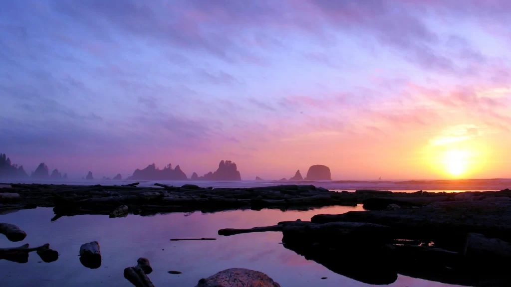Sunset beach ocean rocks clouds reflection