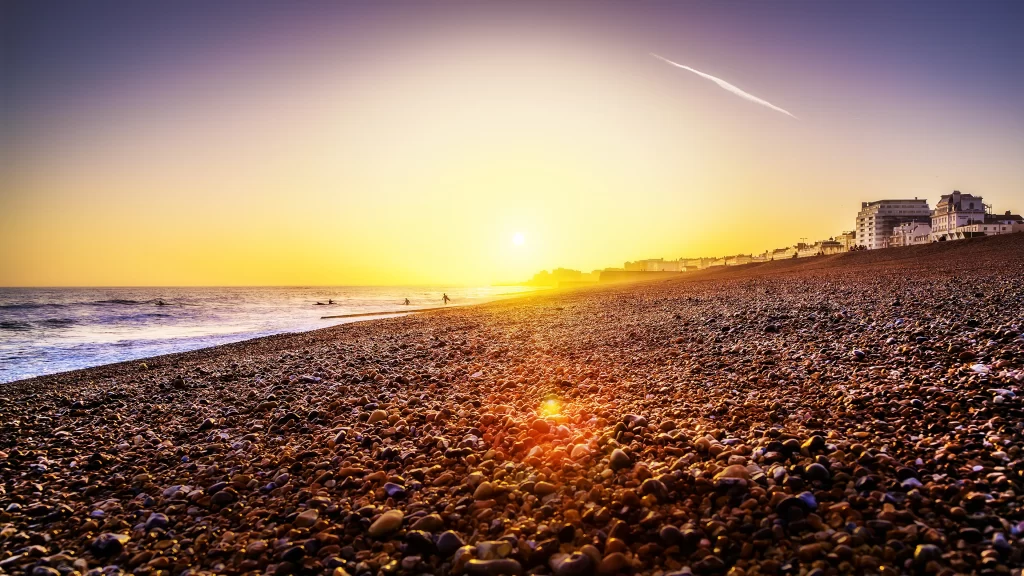 Sunset beach ocean sky buildings pebbles