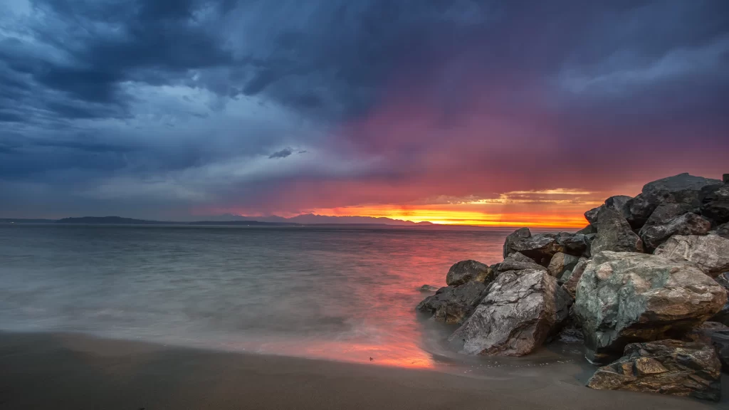 Sunset beach rocks clouds ocean horizon