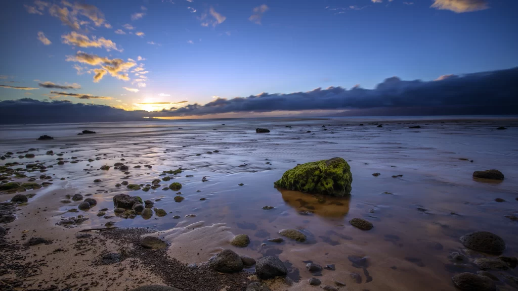 Sunset beach rocks water sky clouds