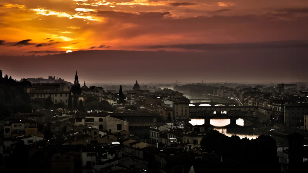 Sunset cityscape bridge river buildings sky clouds orange