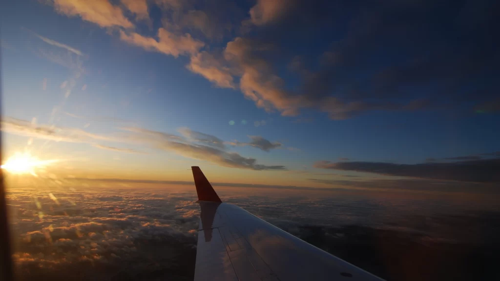 Sunset clouds airplane wing sky horizon