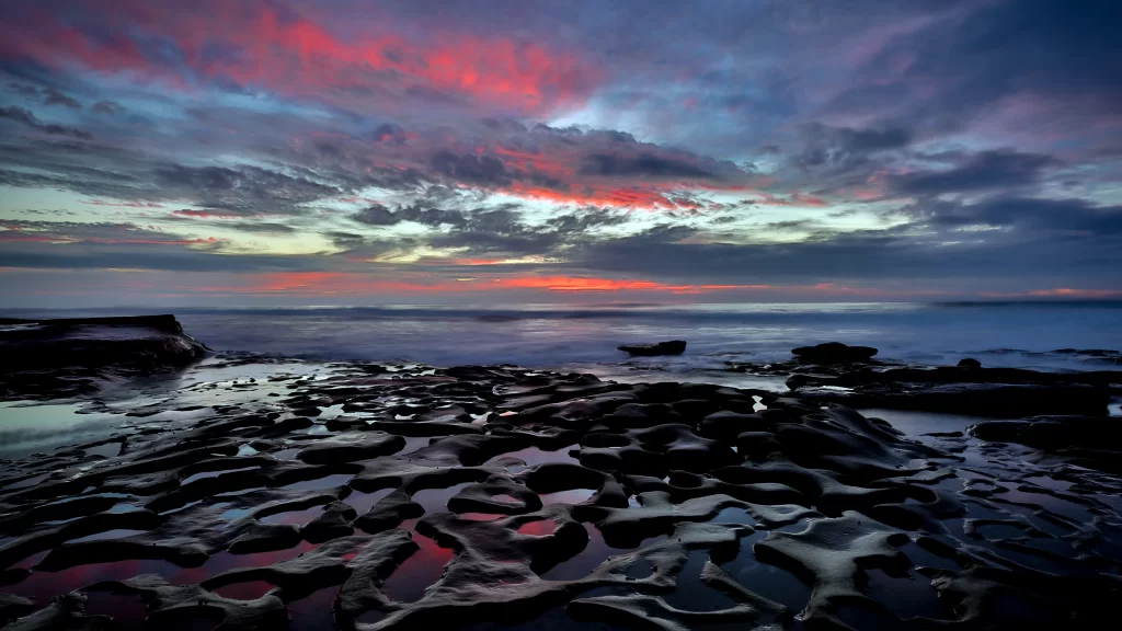 Sunset clouds ocean rocks reflection colors
