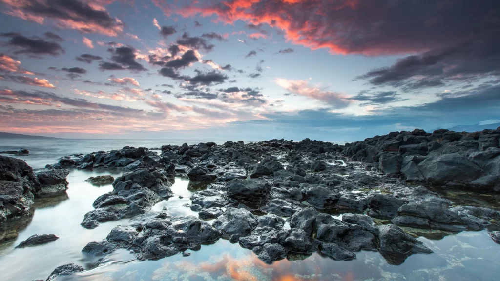 Sunset clouds rocks water reflection sky