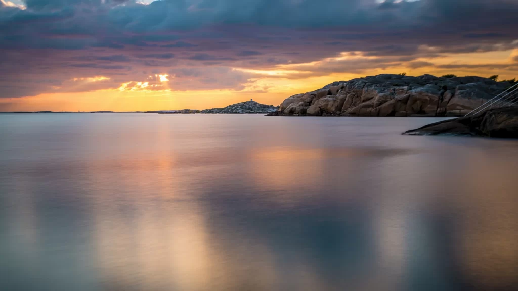 Sunset clouds water reflection rocks sky