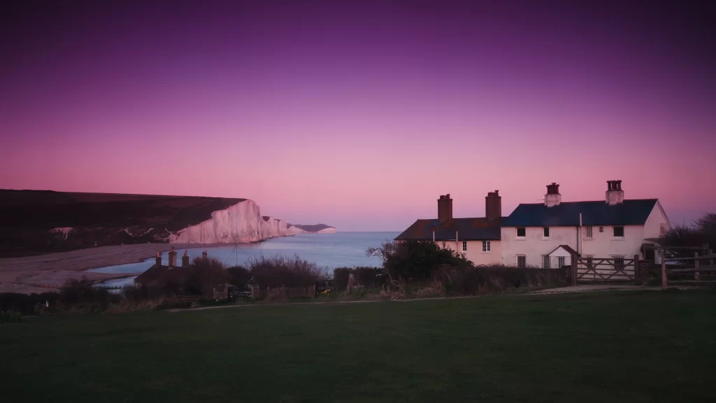Sunset houses cliffs sea sky landscape