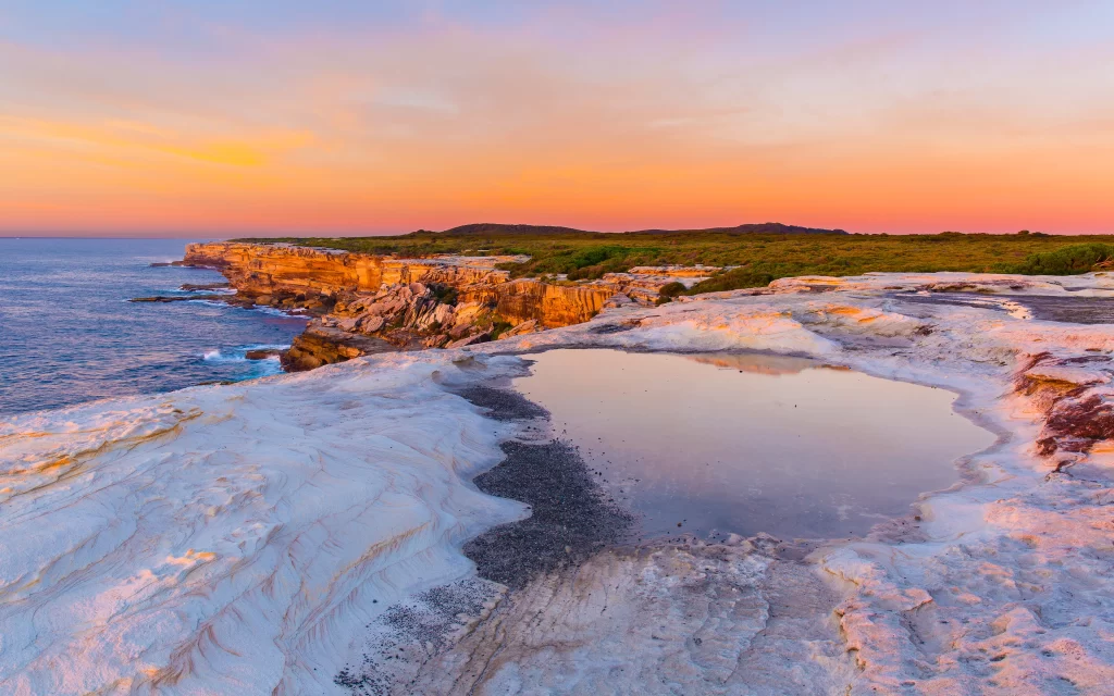 Sunset ocean cliffs rocks sky reflection