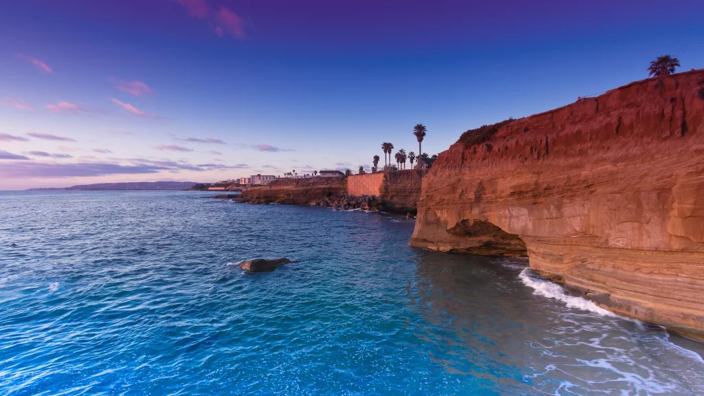 Sunset ocean cliffs waves sky clouds