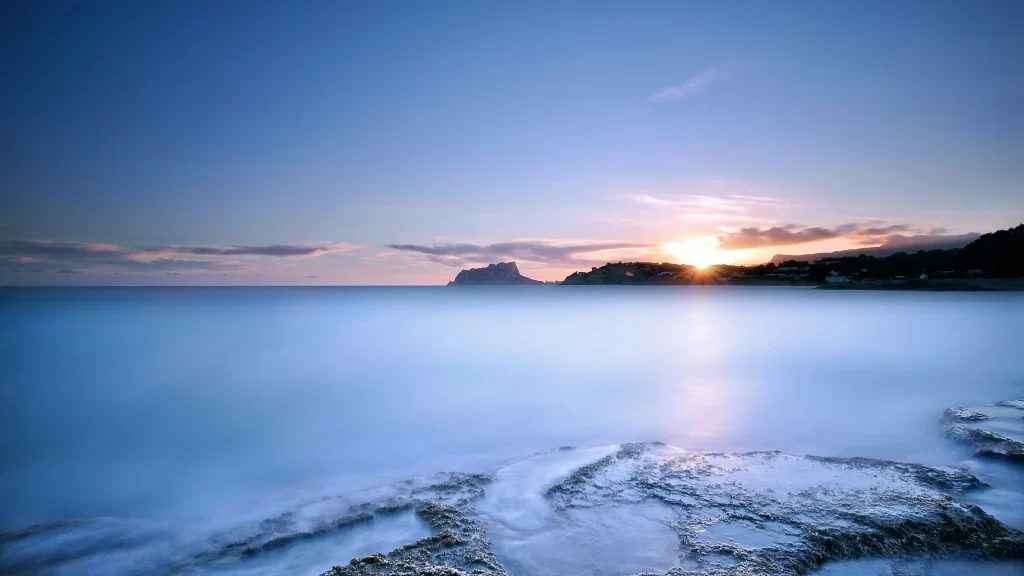 Sunset ocean horizon clouds rocks reflection