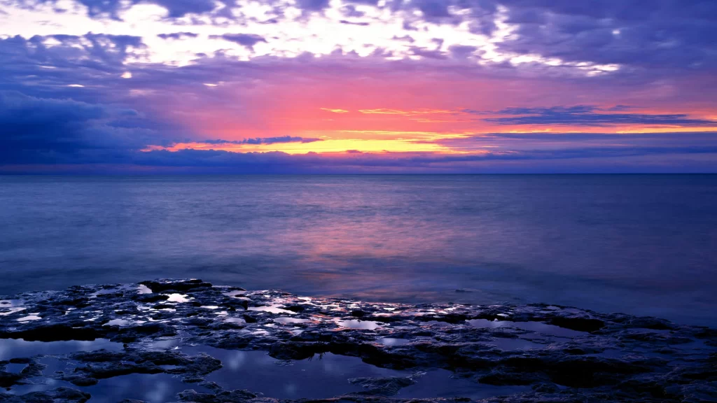 Sunset ocean horizon clouds rocks reflection