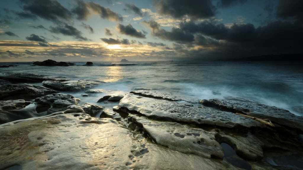 Sunset ocean rocks clouds horizon reflection