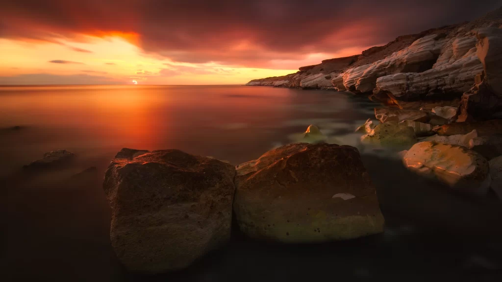 Sunset ocean rocks clouds horizon reflection