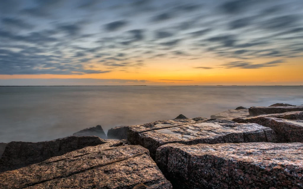 Sunset ocean rocks clouds horizon tranquil