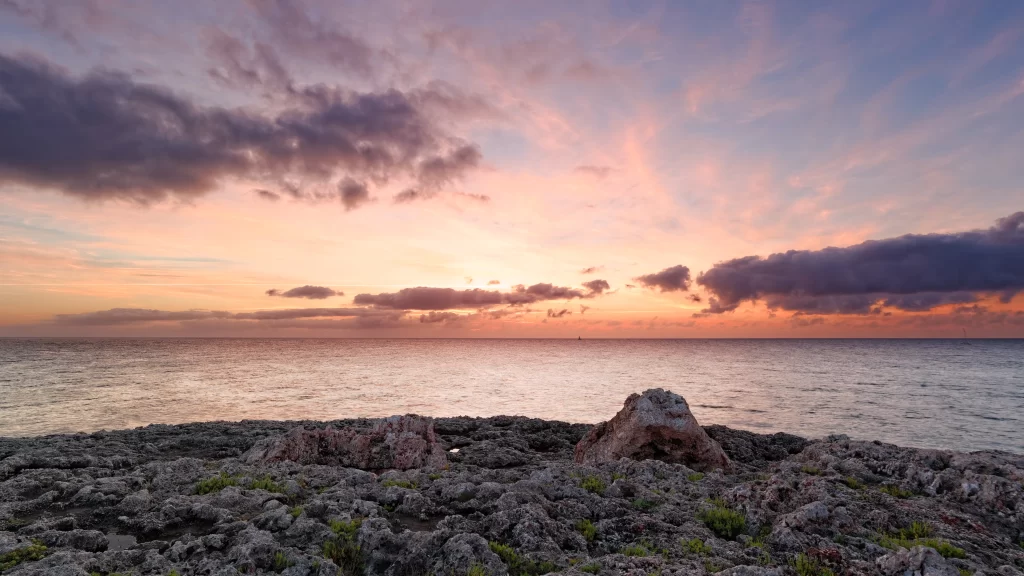 Sunset ocean rocks clouds horizon tranquil