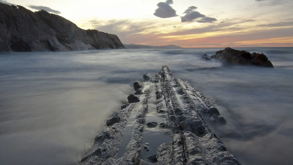 Sunset ocean rocks clouds horizon waves