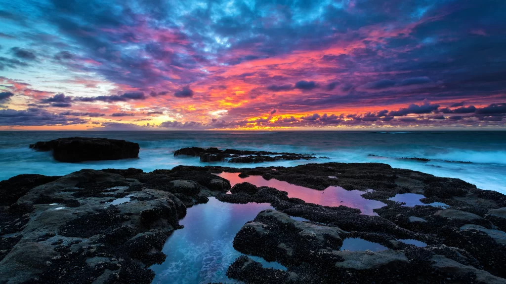 Sunset ocean rocks clouds reflection colors