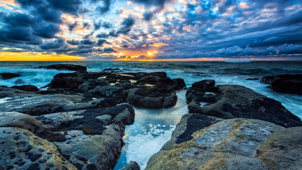 Sunset ocean rocks clouds waves horizon