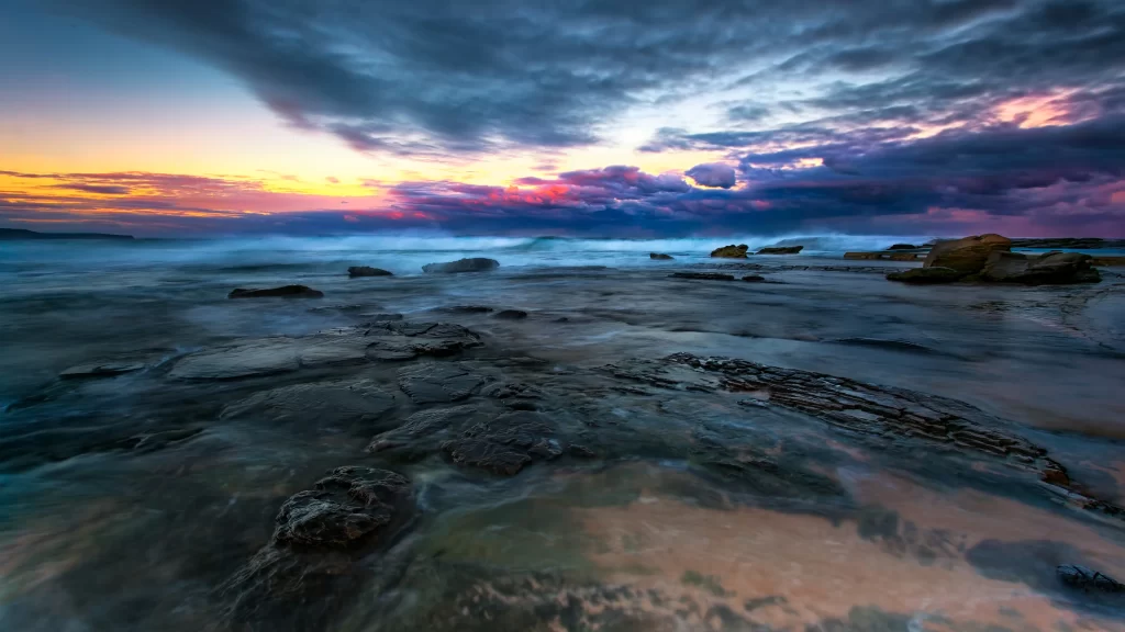 Sunset ocean rocks clouds waves horizon