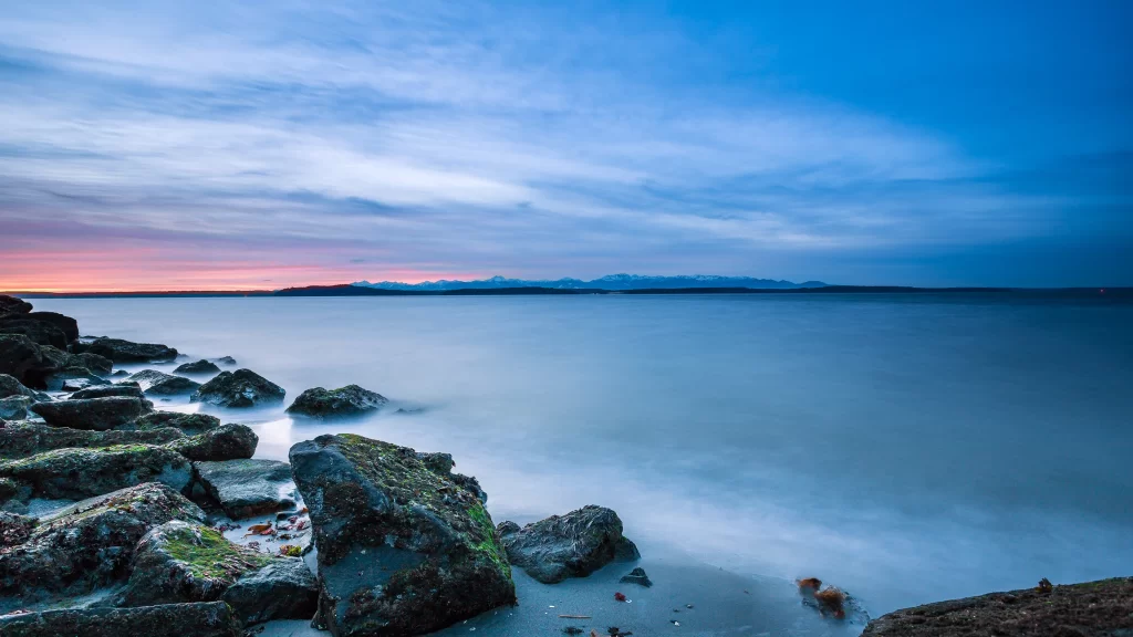 Sunset ocean rocks sky clouds calm