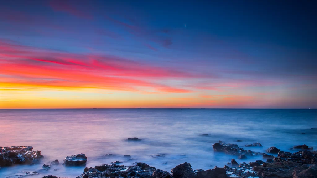 Sunset ocean rocks sky clouds horizon