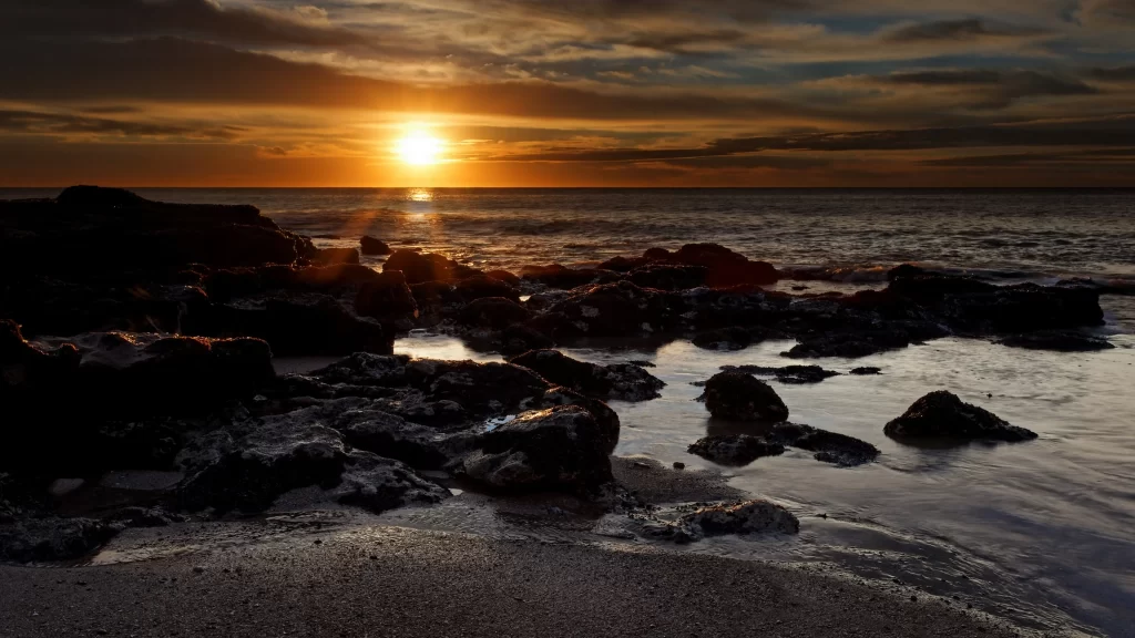 Sunset ocean rocks sky clouds reflection