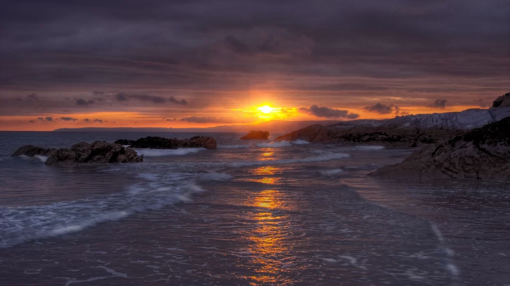 Sunset ocean rocks waves sky clouds