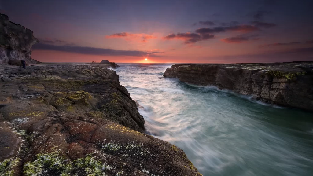 Sunset ocean rocks waves sky clouds
