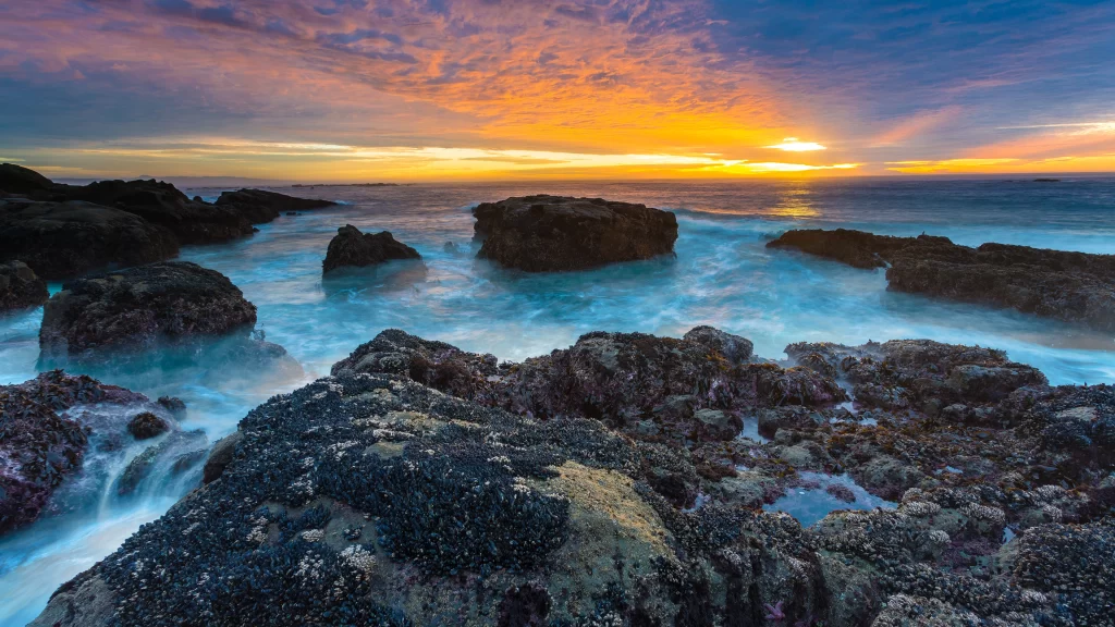 Sunset ocean rocks waves sky clouds