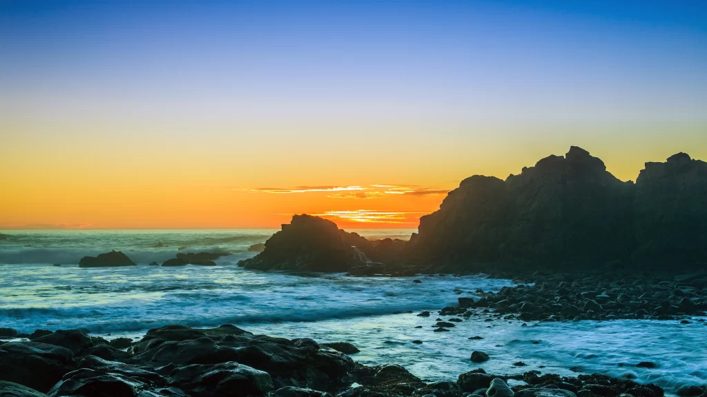 Sunset ocean rocks waves sky horizon