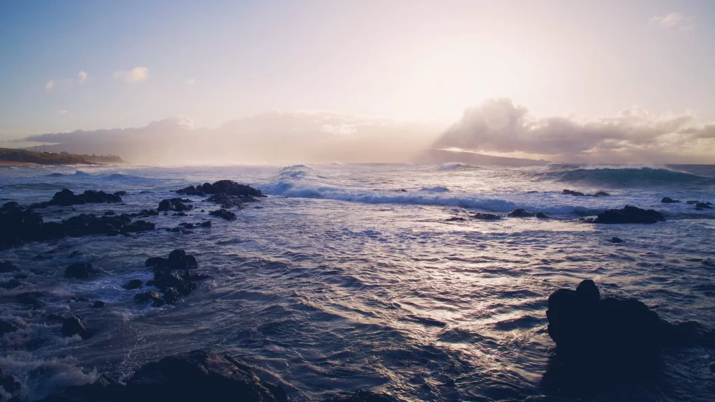Sunset ocean waves rocks clouds horizon