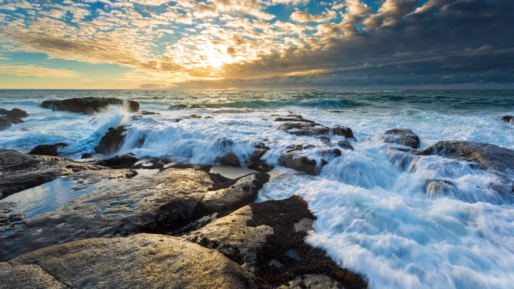 Sunset ocean waves rocks clouds sky