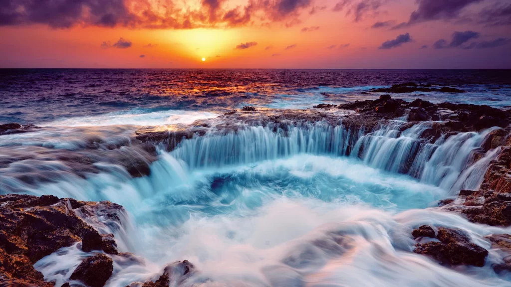 Sunset ocean waves rocks waterfall horizon