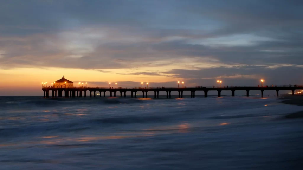 Sunset pier ocean clouds lights horizon