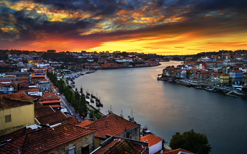 Sunset river cityscape colorful buildings boats sky clouds