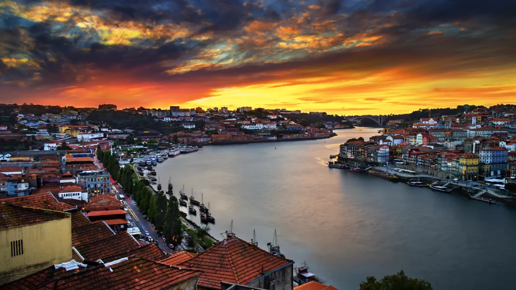 Sunset river cityscape colorful buildings boats sky clouds