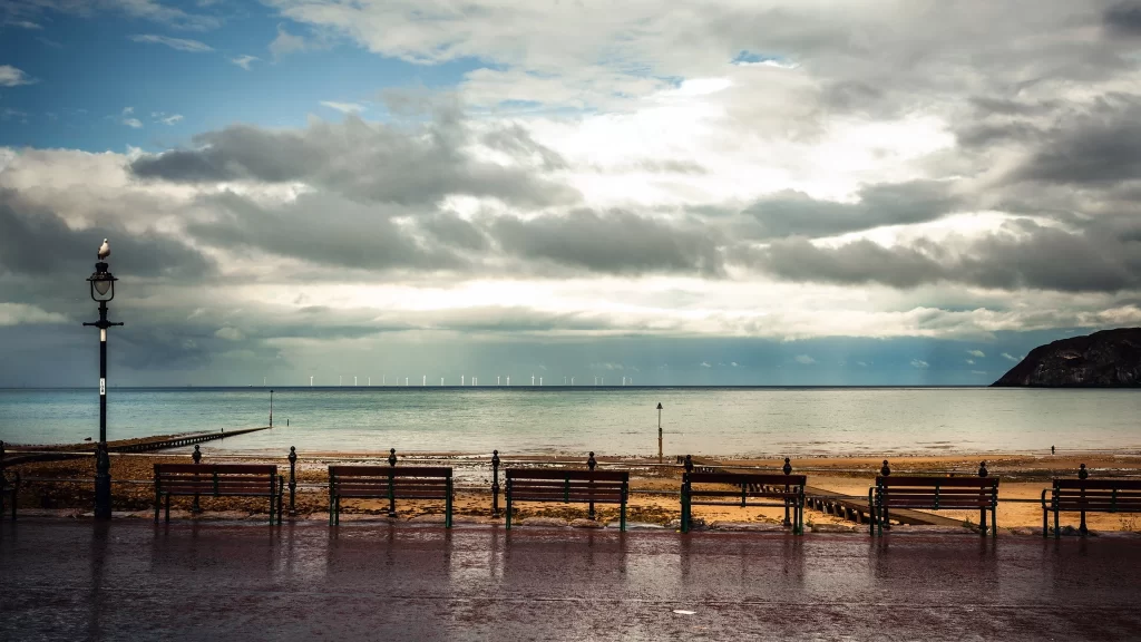 beach benches sea sky clouds lamp post
