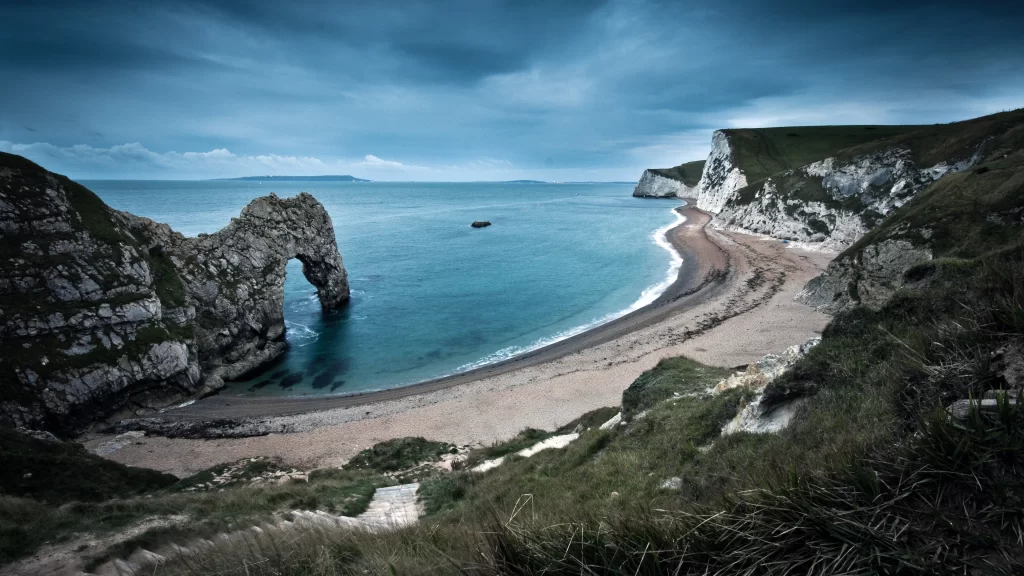 beach ocean cliffs sky clouds rock