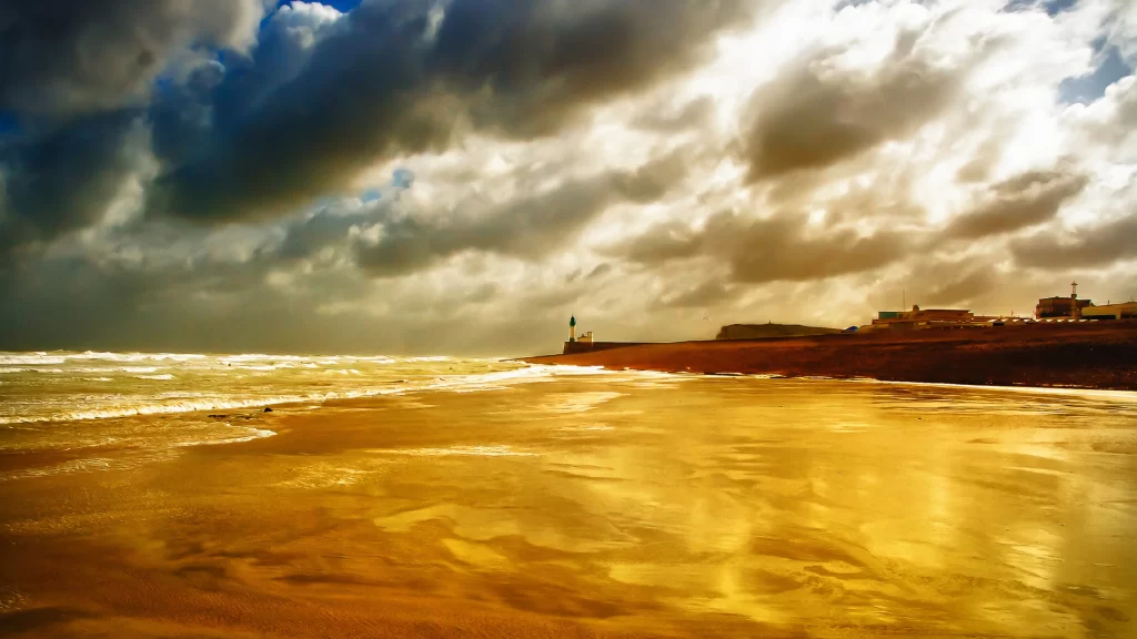 beach ocean clouds sunlight waves lighthouse
