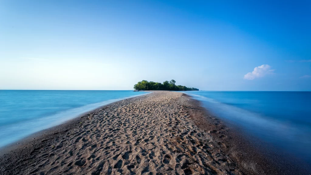 beach ocean sand island sky clouds water horizon