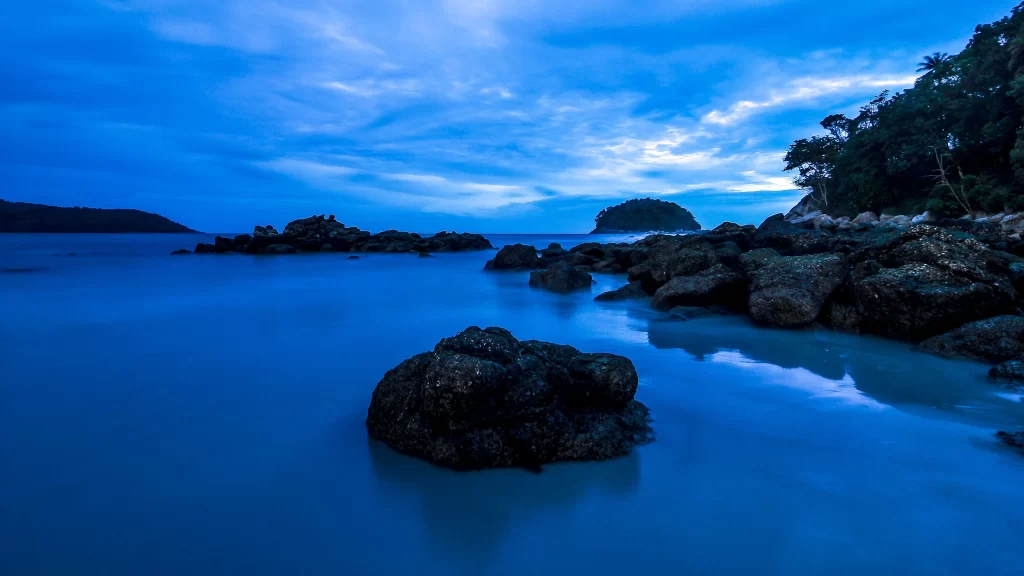 beach rocks water sky clouds sunset