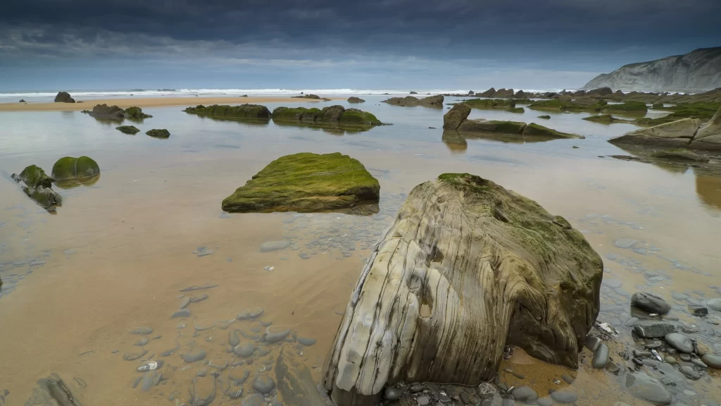 beach rocks water sky sand